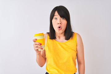 Young beautiful Chinese woman drinking take away coffee over isolated white background scared in shock with a surprise face, afraid and excited with fear expression