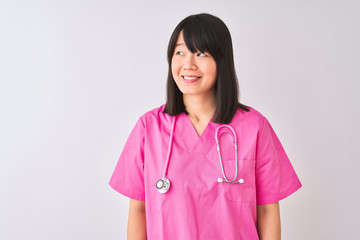 Young beautiful Chinese nurse woman wearing stethoscope over isolated white background smiling looking to the side and staring away thinking.