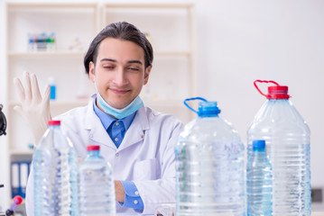 Fototapeta premium Young male chemist experimenting in lab