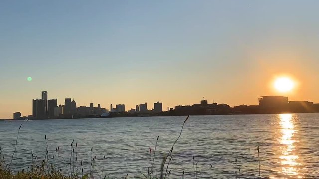 Amazing nature and sunset time lapse by the river and sun sets behind the buildings.