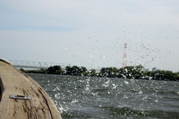 .......波でボートが揺れ水しぶきが上がる川の風景　