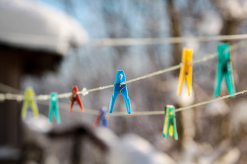 Fototapeta na wymiar Colorful clothespins on a rope in the yard.