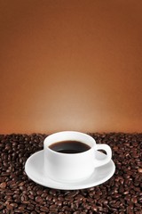 Cup of coffee surrounded by coffee beans
