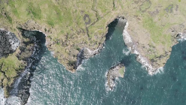 Majestic 4K bird's-eye view aerial of the turquoise North Atlantic ocean and seagulls flying next to the cliffs of Hellnar and Arnarstapi, both popular tourist attraction on the west coast of Iceland.