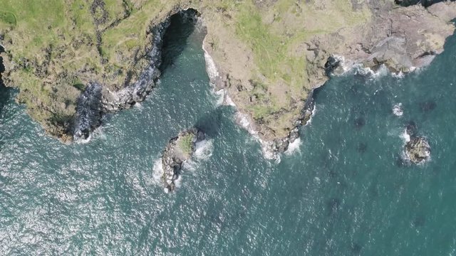 Majestic 4K bird's-eye view aerial of the turquoise North Atlantic ocean and seagulls flying next to the cliffs of Hellnar and Arnarstapi, both popular tourist attraction on the west coast of Iceland.
