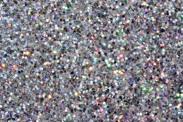 Defocused macro abstract background of sparkling silver glitter texture