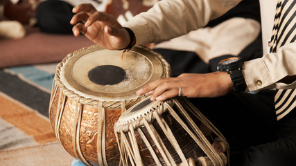 A Student performing and playing with Indian traditional musical instrument "Tabla".