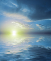 Fototapeta na wymiar Unreal sunset of blue color reflected in calm sea water.