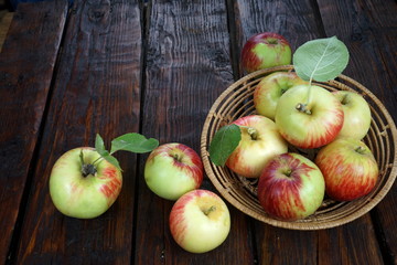 apples in a basket on a dark wooden table