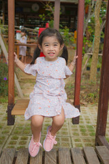 little girl sitting on swing
