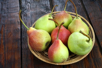 pears in a basket on a dark wooden table