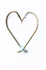 Love of fishing, heart made of fishing hooks isolated on white