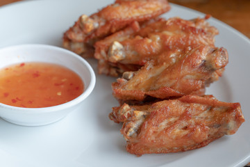 Fried chicken wings serve with sweet sauce on white dish