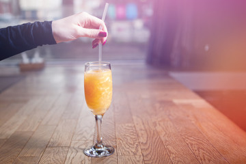 Glass with a yellow cocktail on the bar counter.