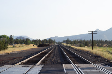 Fototapeta na wymiar Two rail ways with leading lines into the mountainous distance in Central Oregon near Smith Rock National Park