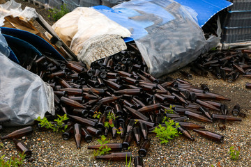  packed bottles in pallets, lots of empty broken bottles on asphalt and garbage from production abandoned glass factory.