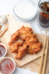 Hot and spicy Korean barbeque fried chicken on wood cutting board