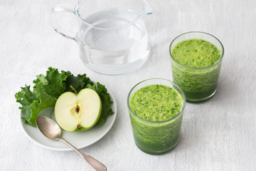 Green smoothie with kale cabbage and apple on a gray background. delicious healthy vegan food	