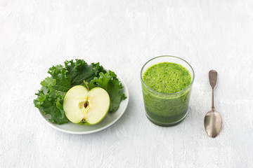 Green smoothie with kale cabbage and apple on a gray background. delicious healthy vegan food	