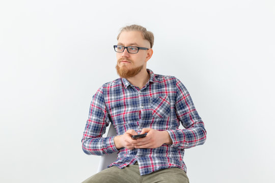 Young hipster bearded man sitting over the white background with copy space