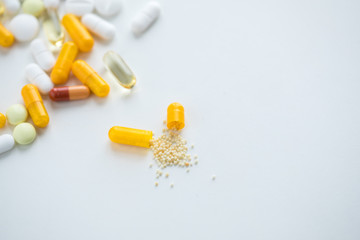 Gelbe und weiße Pillen Kapseln und Tabletten auf weißen Hintergrund
