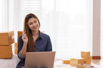 SME entrepreneur Young Asian women working with laptop thinking for marketing Online shopping at home,Happy with box for packaging in home,Own Business Start up for Business Online and Online shopping