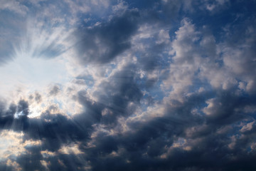 The sun's ray passes through the cirrus clouds in the blue sky.