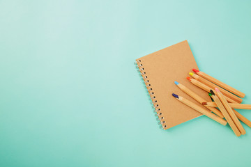 Crayon With a notebook on blue
