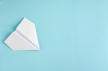 White paper plane on blue background composition.