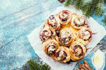 Homemade delicious cinnamon rolls with lemon and berries over blue background, top view