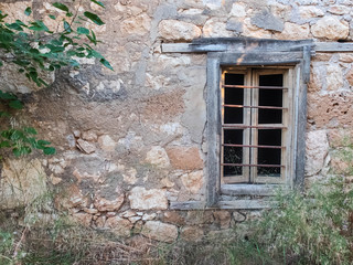 Old abandoned stone mansion with bars on the window