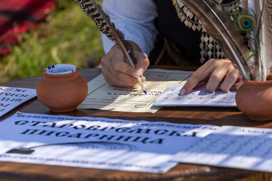 Signing a parchment piece of paper with feather