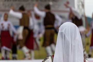 Girl watching folklore concert event on a stage