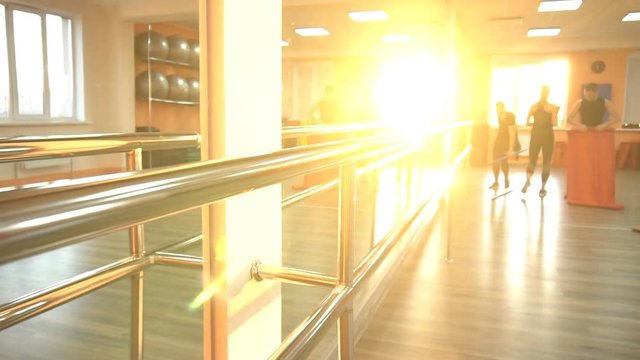Men and girls are prepared before the start of training in the fitness center on the background of a sunset, slow motion, lifestyle