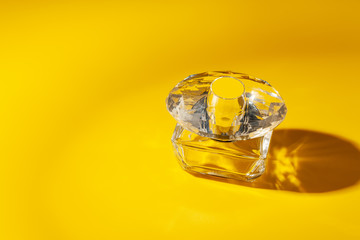 perfume glass bottle on light yellow background. Eau de toilette