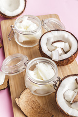 Broken coconut pieces on bright pink background, top view, copy space