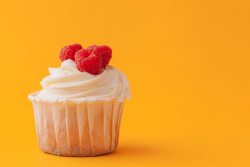 Delicious cupcakes with icing on a yellow background