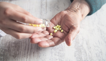 Hand of elderly woman with pills.