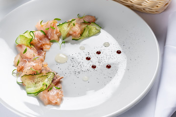 sliced fish fillet with cucumber and pea leaves