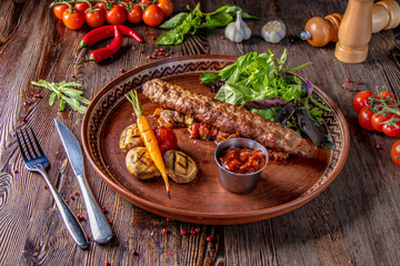 Obraz na płótnie Canvas Turkish and Arabic Traditional Ramadan mix kebab plate, Kebab lamb and beef with baked vegetables, mushrooms and tomato sauce, close-up, horizontal photo