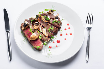 chopped beef steak with champignons, young peas and red sauce