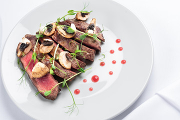 chopped beef steak with champignons, young peas and red sauce