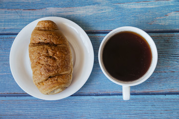 Top view croissant and coffee on wooden table