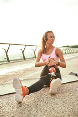My perfect morning. Vertical photo of beautiful woman in headphones listening music and stretching...