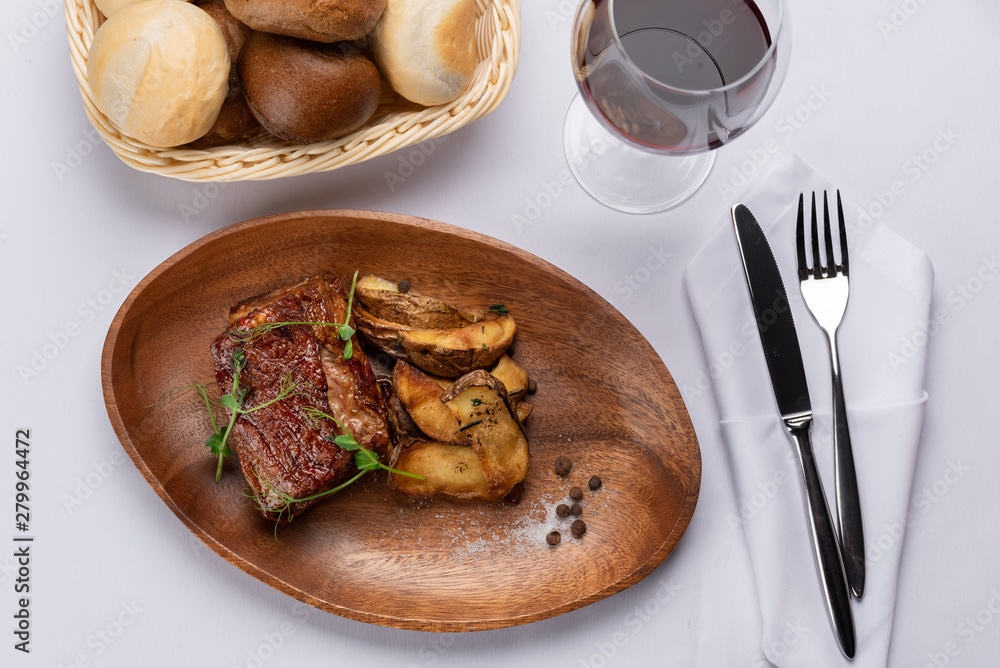 Wall mural fried beef stake with potatoes and sprouted peas on a white table