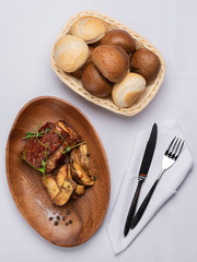 fried beef stake with potatoes and sprouted peas on a white table