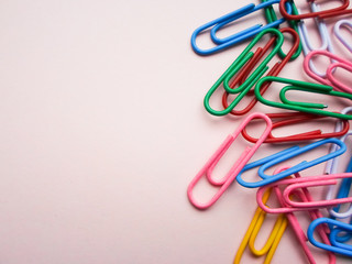 multicolored paper clips on a pink background. The concept is time to school.