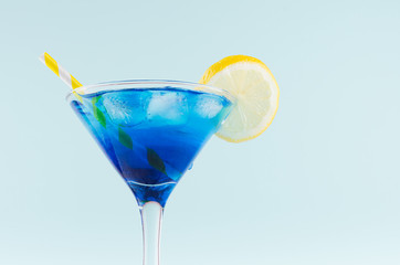 Exquisite blue cocktail for celebration in beach style with blue curacao, ice cube, lemon slice,...