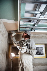 Fototapeta premium Construction worker plastering gypsum walls inside the house.