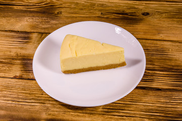 White plate with cheesecake New York on wooden table